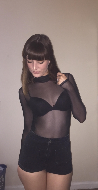 Posing in a black transparent bodysuit