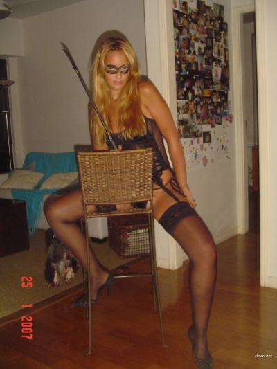 Девушка в маске сексуально позирует